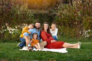 Family sitting at buckeye woods park Medina, Ohio surrounded by fall foliage