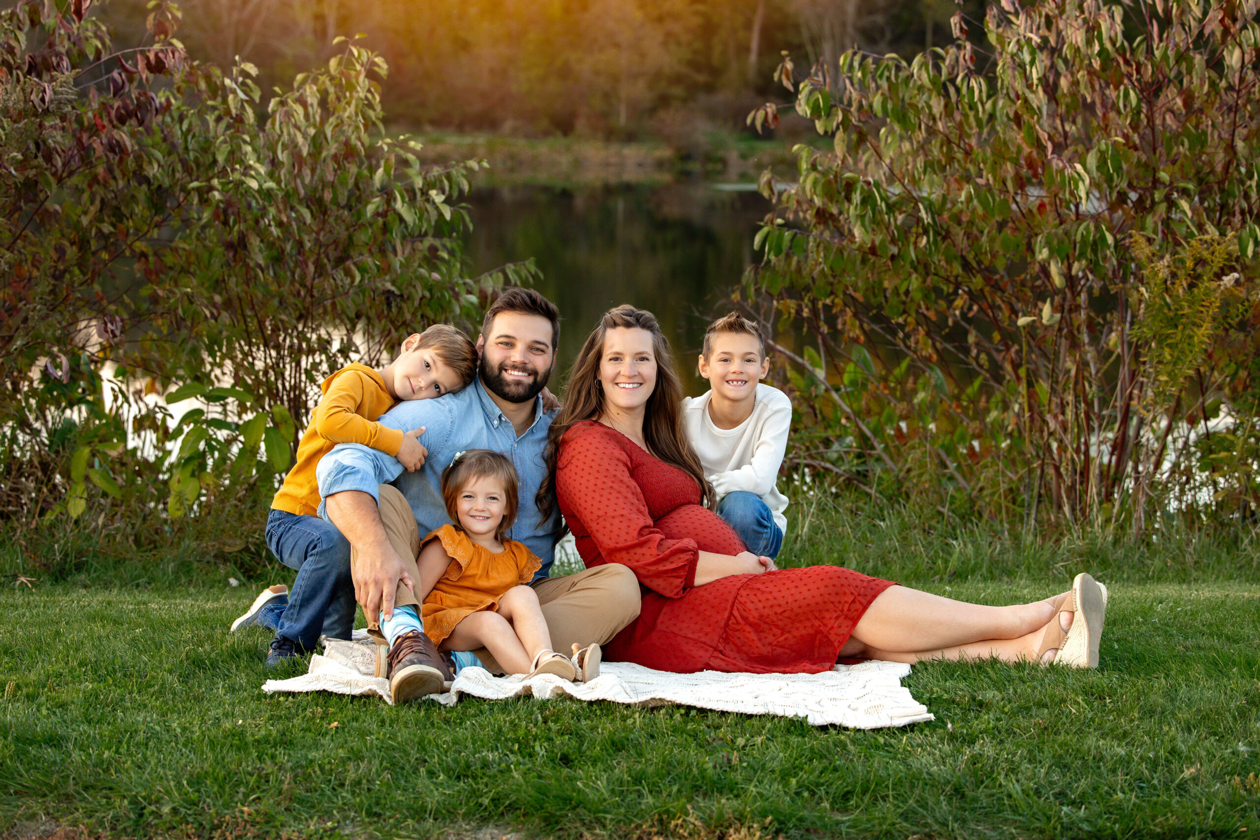 Family sitting at buckeye woods park Medina, Ohio surrounded by fall foliage
