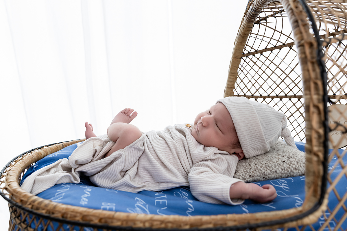 newborn relaxed sleeping in a cradle