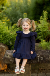 Little girl with pig tails smiling at the camera 