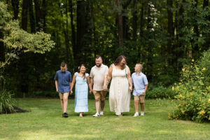 Candid moment of extended family laughing together during lifestyle photography session in a rustic countryside setting.
