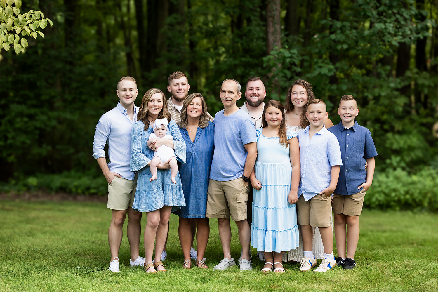 Extended family photo session outdoors with three generations smiling together during golden hour