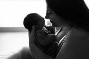 Mom looking down at her newborn, nose to nose, in her hospital room at her fresh 48 session 