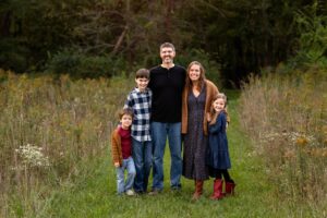 A family poses together at their fall family session cuddled in close 