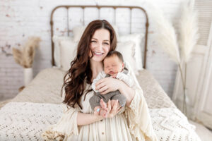 mom holding baby smiling with joy after picking outfits from client closet