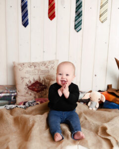 little boy smiles while playing with his harry potter book gifts from chrismtas 