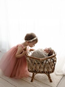 little girl looks down at her newborn sister at photography studio just north of the medina square during the medina ice festival