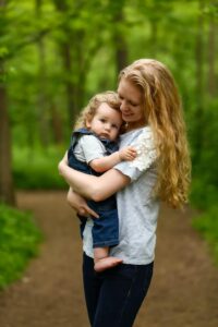 mom holds her baby close at hubbard valley park for her motherhood mothers day photo session 