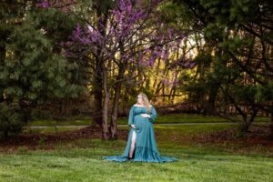 Family Maternity portraits at Medina park in Medina Ohio during spring with blooming trees and historic buildings in the background.